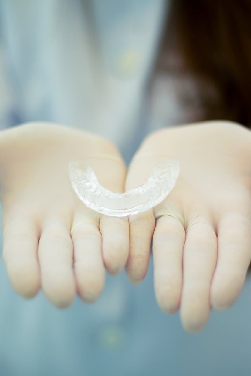 a clear retainer on a person s hands wearing gloves